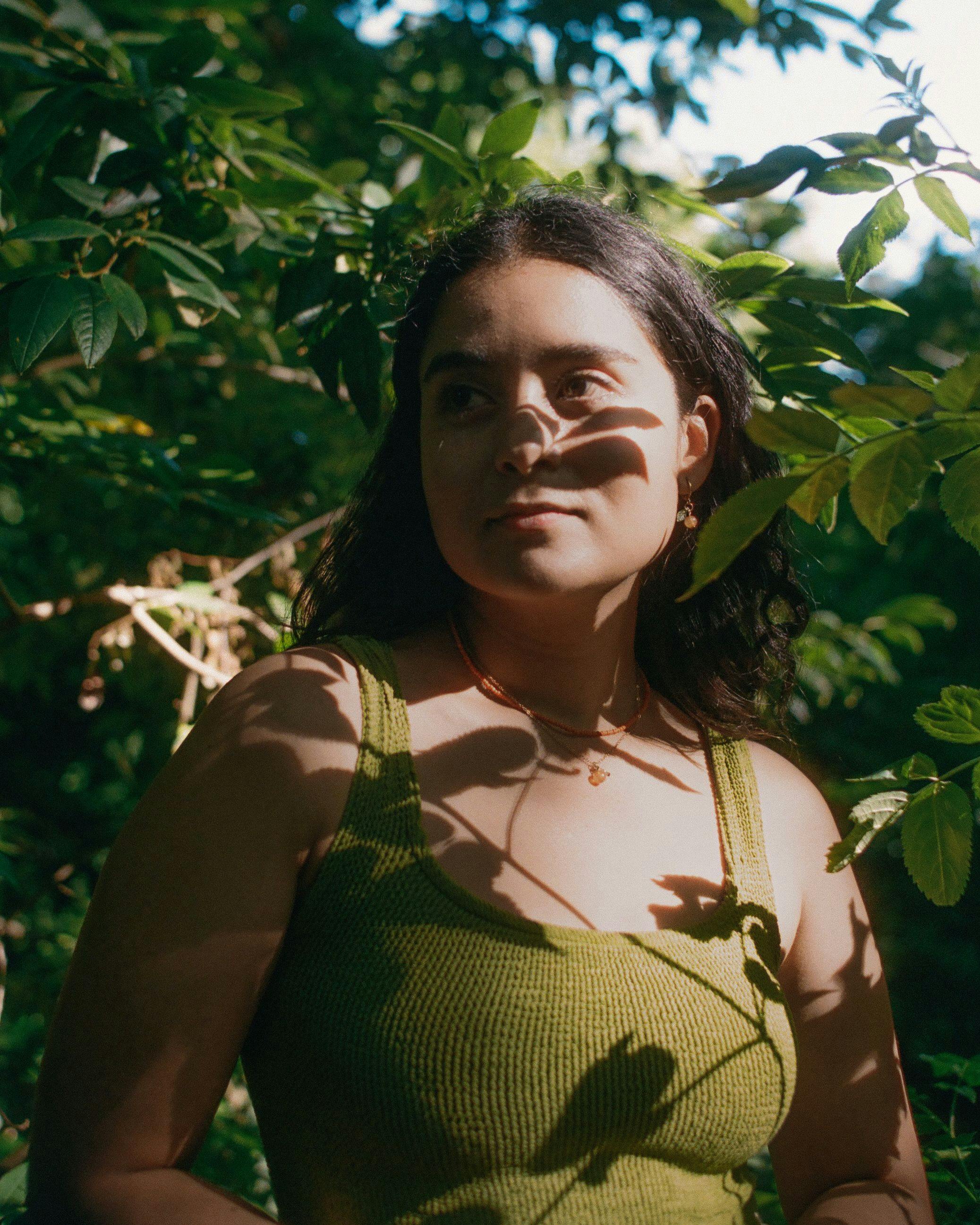 Divya in the shadow of leaves wearing green swimsuit