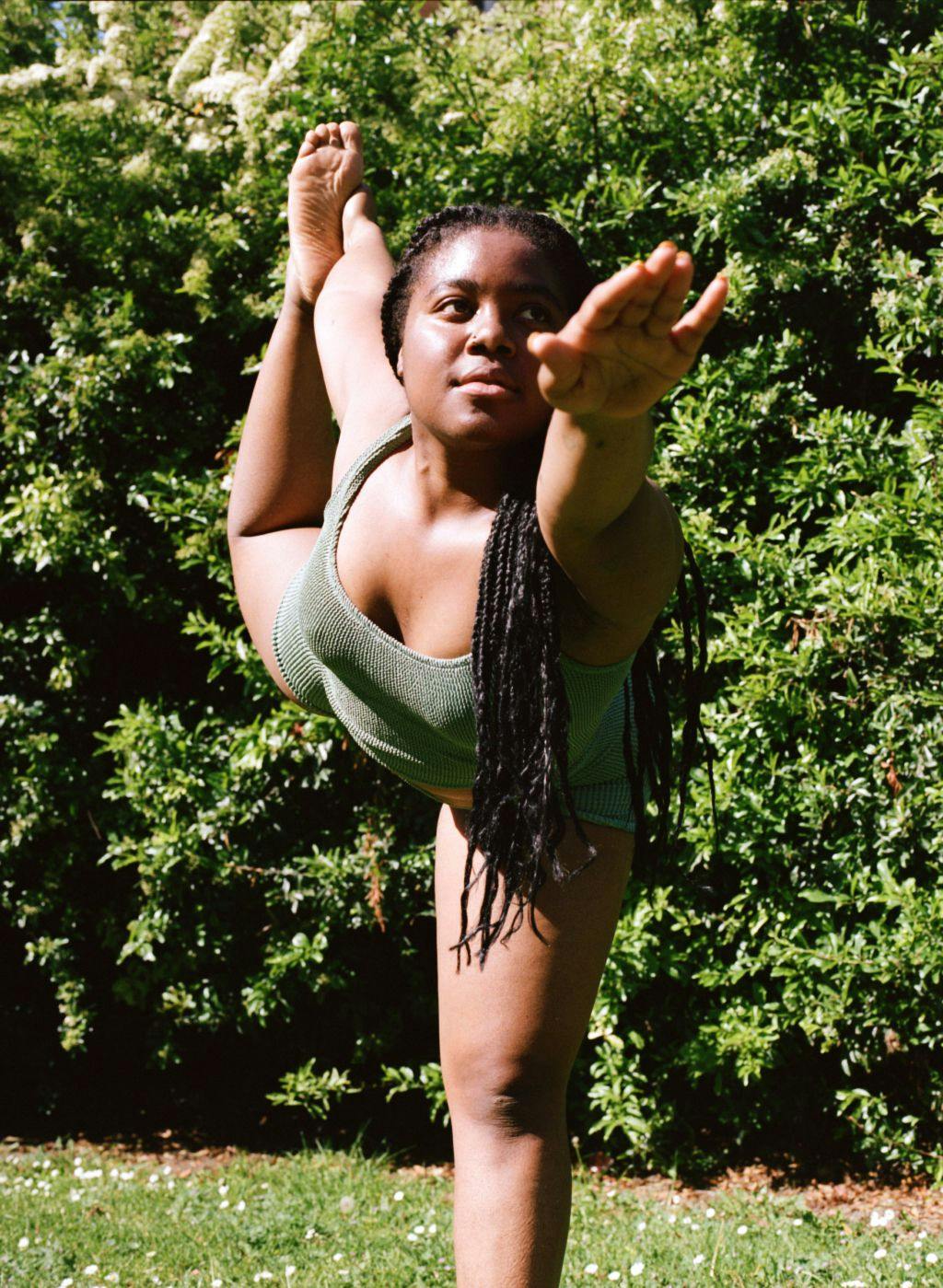 Esther stretching in green swimsuit top and shorts 