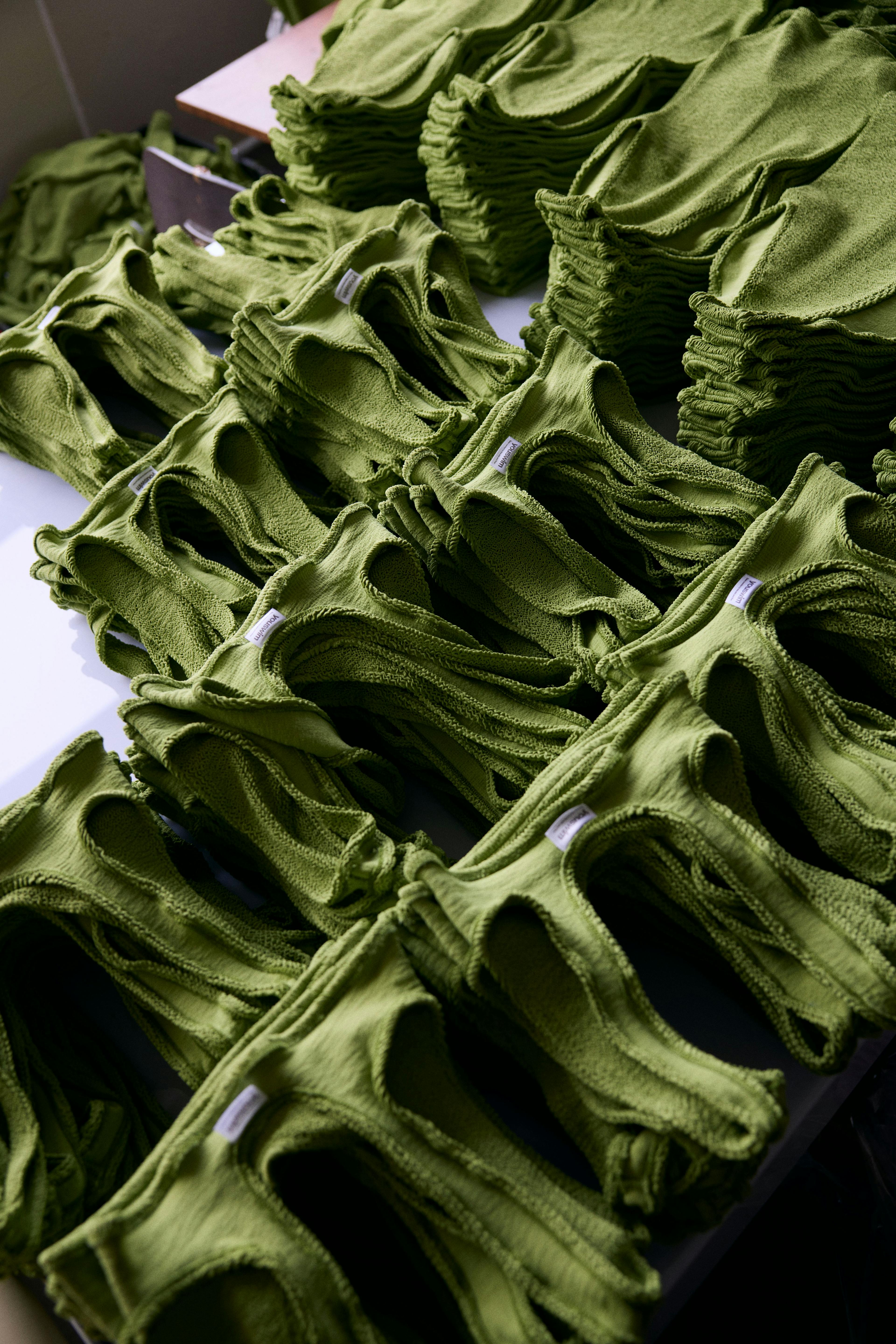 Table of multiple green swiimsuits.